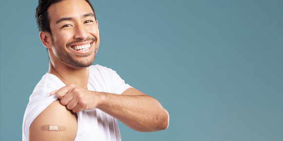 Man smiling showing off arm with bandage